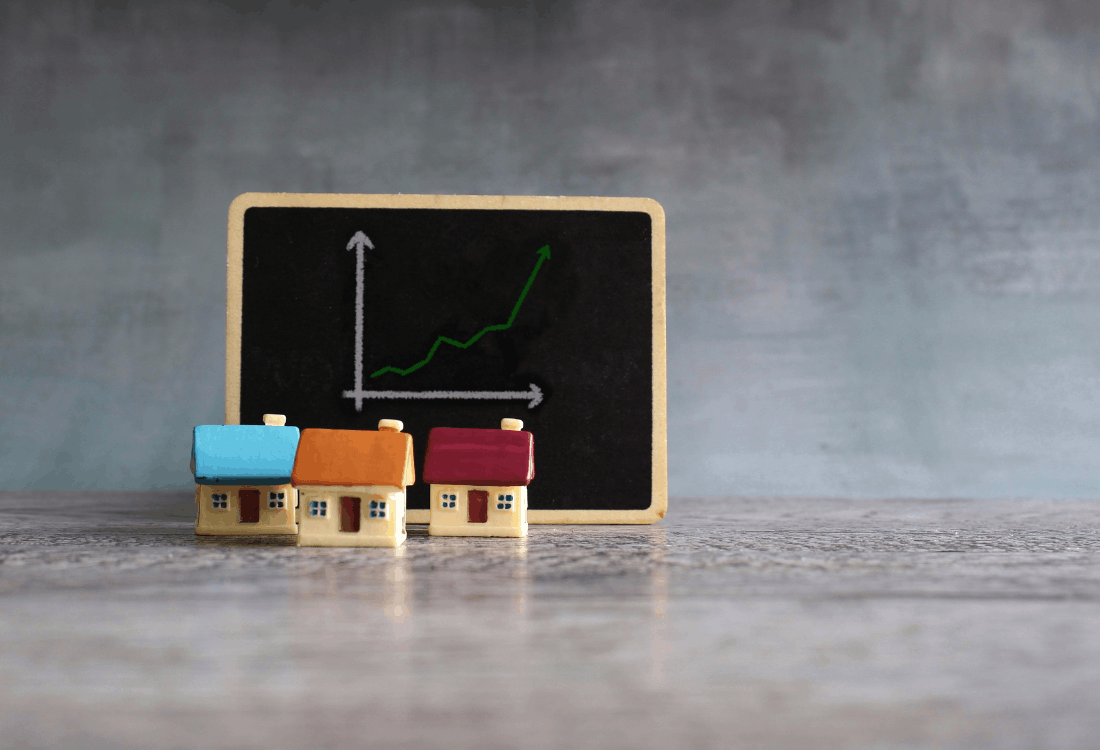 Miniature model houses in front of a chalkboard showing an upward-trending graph, symbolising shifting rental market dynamics where some landlords exit while strategic investors capitalise on growth opportunities.